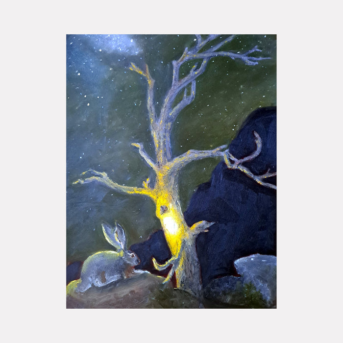 The artwork 'Black Tailed Jackrabbit' by Johanna Ryan depicts a mystical nighttime scene with a luminous tree trunk glowing yellow against a deep forest-green background. A detailed jackrabbit rests near grey rocks beneath the twisted, silvery branches, surrounded by starry specks in the dusky atmosphere. Oil on mylar painting captures ethereal lighting effects.
